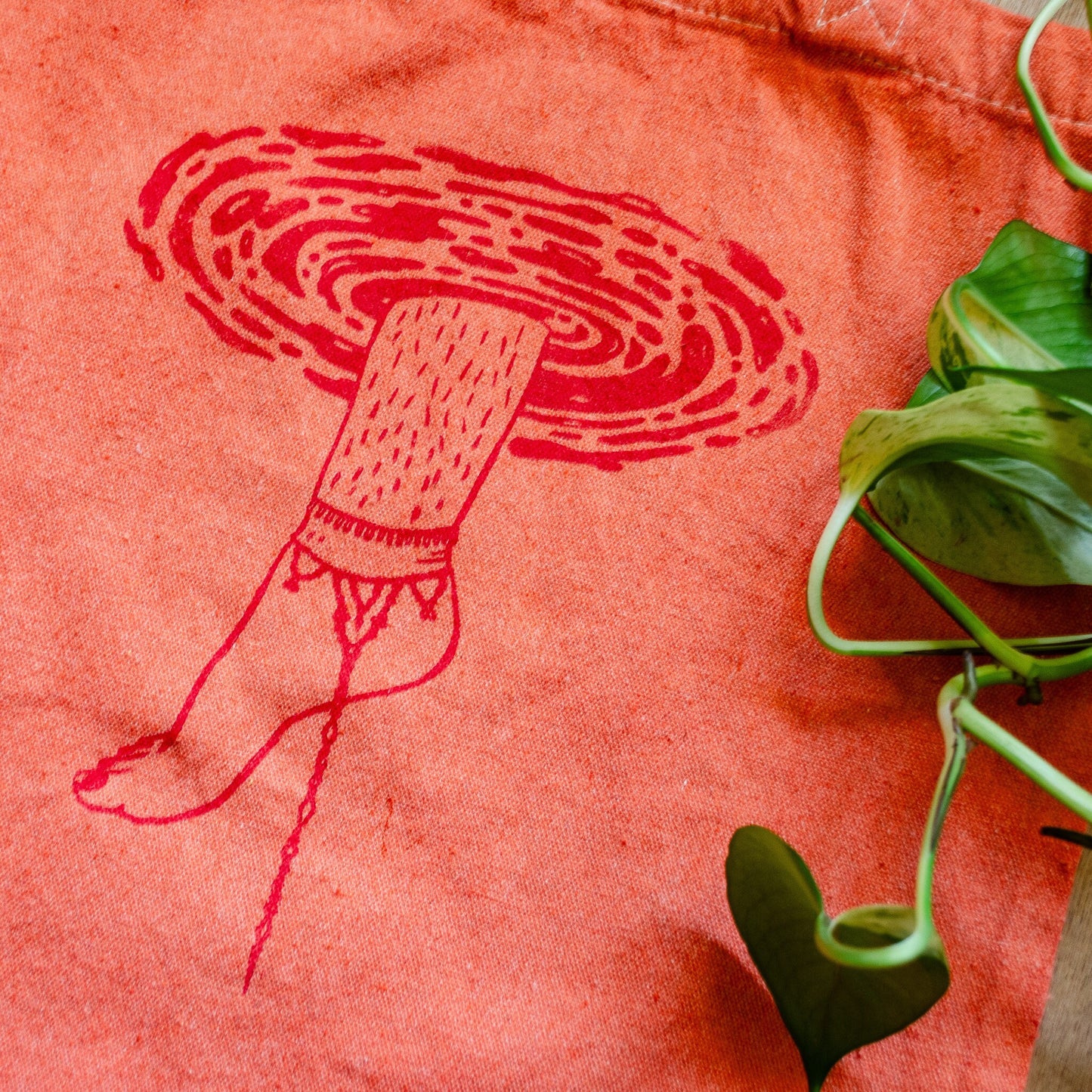 Illustration of leg slipping into a pool on an orange tote bag