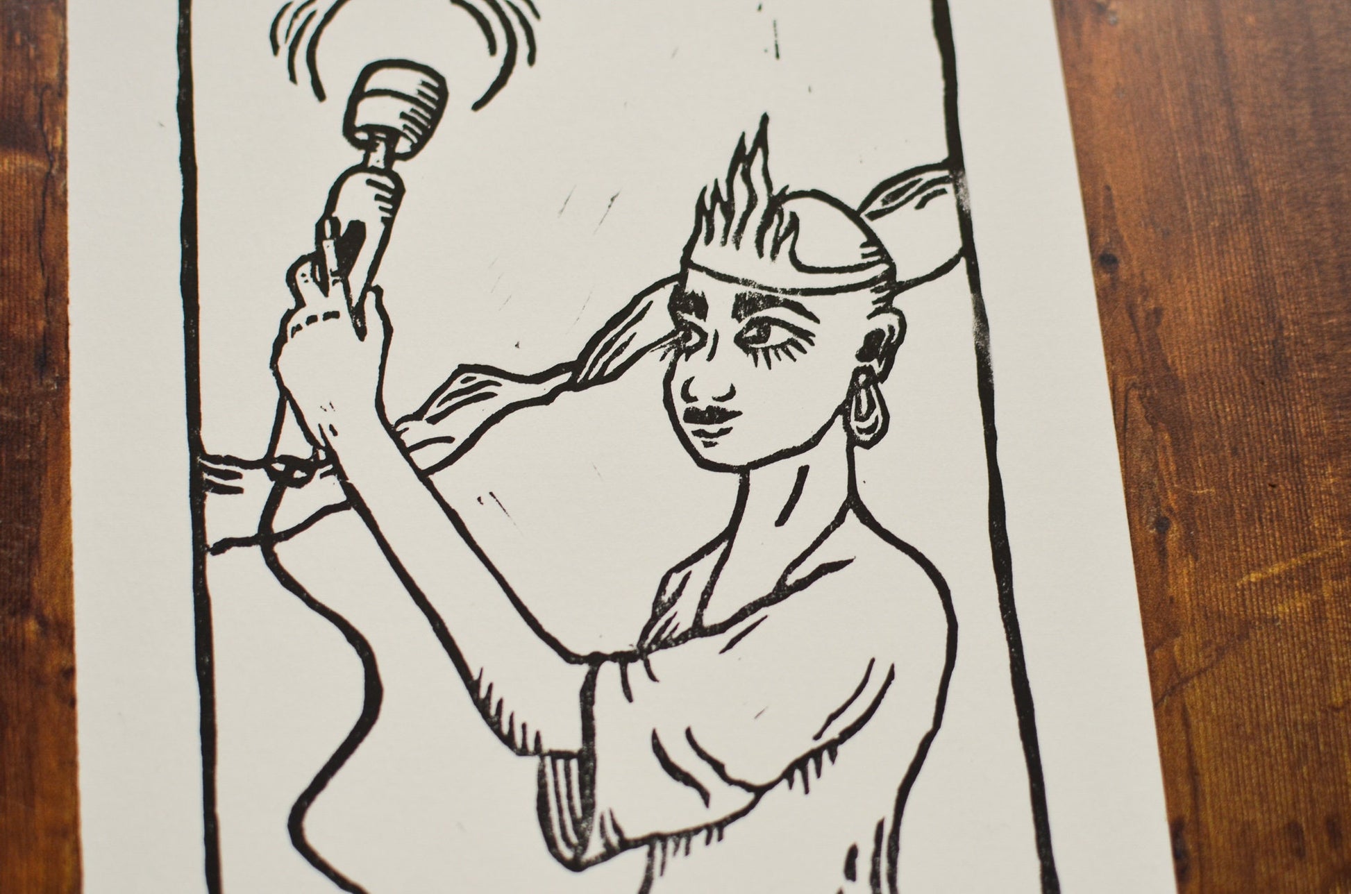 Black and white illustration of a person holding a hitachi wand on a wooden surface