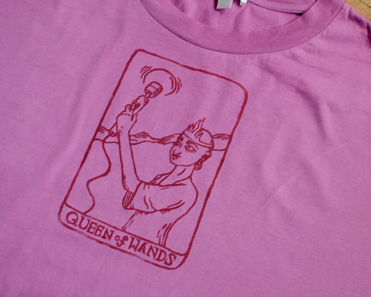 Pink t-shirt with a queen of wands tarot card design.